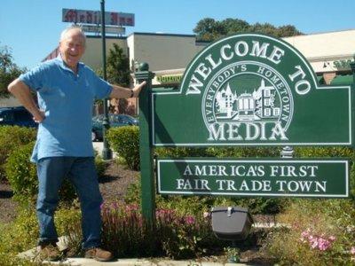 Man standing next to the Welcome to Media sign